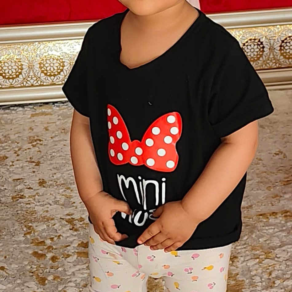 Leen participe au concours pour gagner de l'argent avec cette photo : barefoot, black_tshirt, blanket, carpet, child, couch, curly_hair, cute, expression, fashion, furniture, home, indoor, leggings, person, portrait, red_bow, standing, toddler, young_child