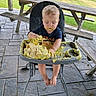 Bray is registered to the contest to win money with this photo: baby, blond_hair, cake, child, closed_eyes, eating, food, frosting, high_chair, lawn, messy, outdoor, patio, picnic, playful, portrait, sitting, summer, toddler, wooden_table