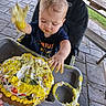 baby, birthday, cake, celebration, child, cream, eating, face, food, frosting, hands, high_chair, messy, outdoor, patio, portrait, smiling, stone_pavers, wooden_bench, yellow