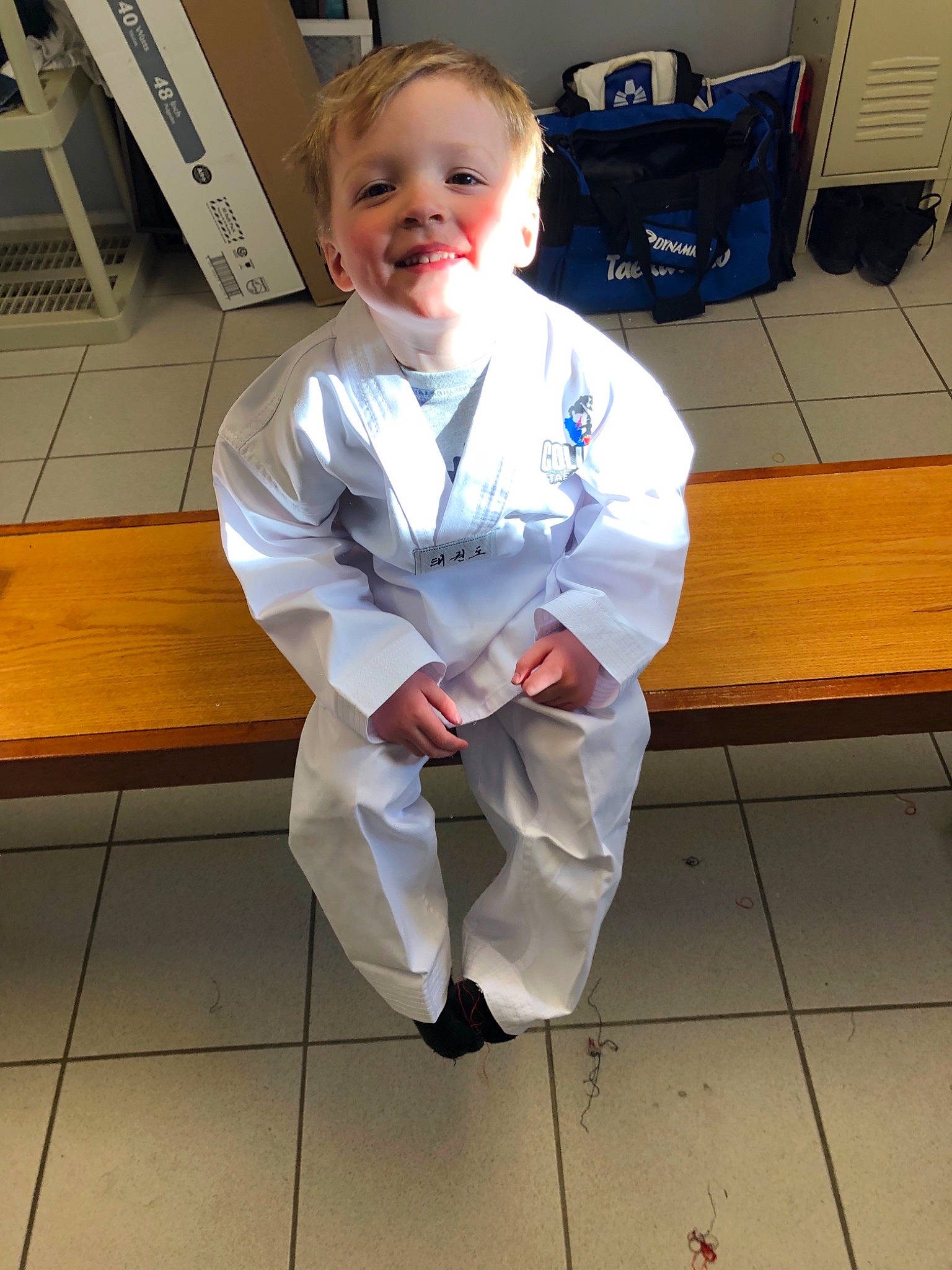 Keagan is registered to the contest to win money with this photo: child, costume, joy, person, sitting, smile, taekwondo, toddler, uniform