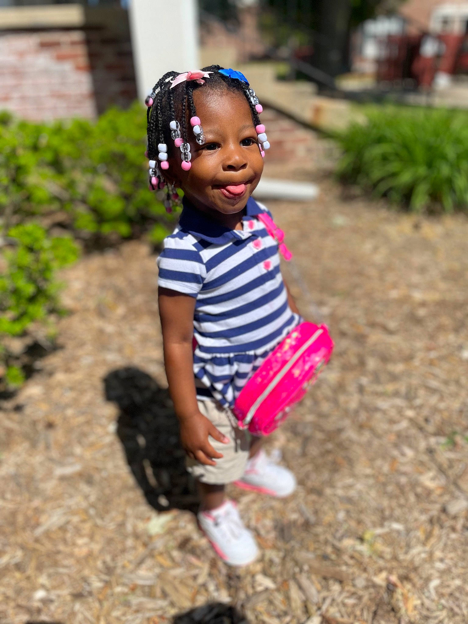 Nalani is registered to the contest to win money with this photo: baby_toddler_clothing, boot, eye, face, fun, grass, happy, head, leisure, pattern, people_in_nature, person, plant, recreation, sandal, shorts, smile, sneakers, soil, toddler