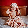 Miguel a rejoint le concours — aidez-le/la à gagner de superbes lots ! baby, towel, bed, child, smile, face, headboard, red_wall, wood, cute, curious, indoor, blanket, skin, foot, hand, expression, sitting, hood, texture