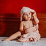 Miguel participe au concours pour gagner de l'argent avec cette photo : toddler, child, baby, towel, pink, bed, wooden_headboard, indoors, curious, hooded_towel, skin, sitting, expression, cute, portrait, room, blanket, soft, comfort, red_wall
