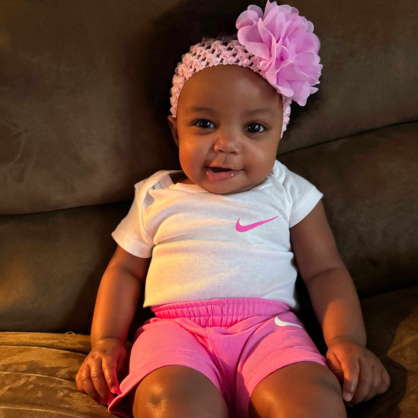 Zayanni joined the competition — help win amazing prizes! baby, child, clothing, couch, cute, fashion, flower, happy, headband, indoor, infant, person, pink_shorts, portrait, relaxed, sitting, skin, smiling, white_shirt, young_child