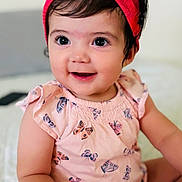 Antonella is registered to the contest to win money with this photo: baby, child, girl, smile, headband, bow, butterfly_pattern, pink_clothing, cute, happy, sitting, bracelet, indoor, portrait, young_child, skin, face, eyes, hand, infant