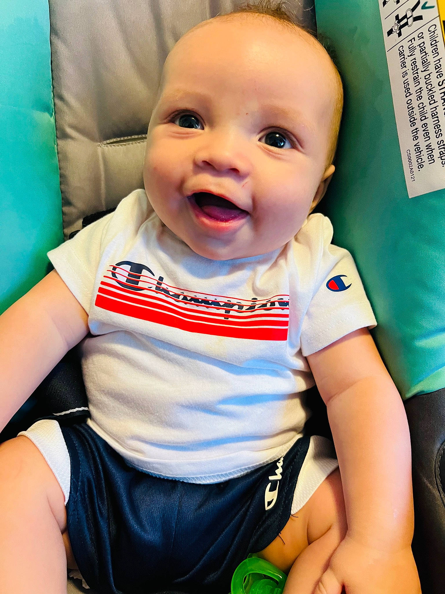 Caiden is registered to the contest to win money with this photo: arm, baby, baby_toddler_clothing, blue, cheek, chin, clothing, eye, facial_expression, finger, happy, human, iris, mouth, nose, person, skin, sleeve, smile, toddler