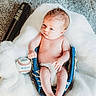 baby, infant, baseball_glove, baseball, bat, blanket, carpet, diaper, blue, sports_equipment, soft_texture, cute, small, lying_down, indoors, person, newborn, relaxed, fingers, feet