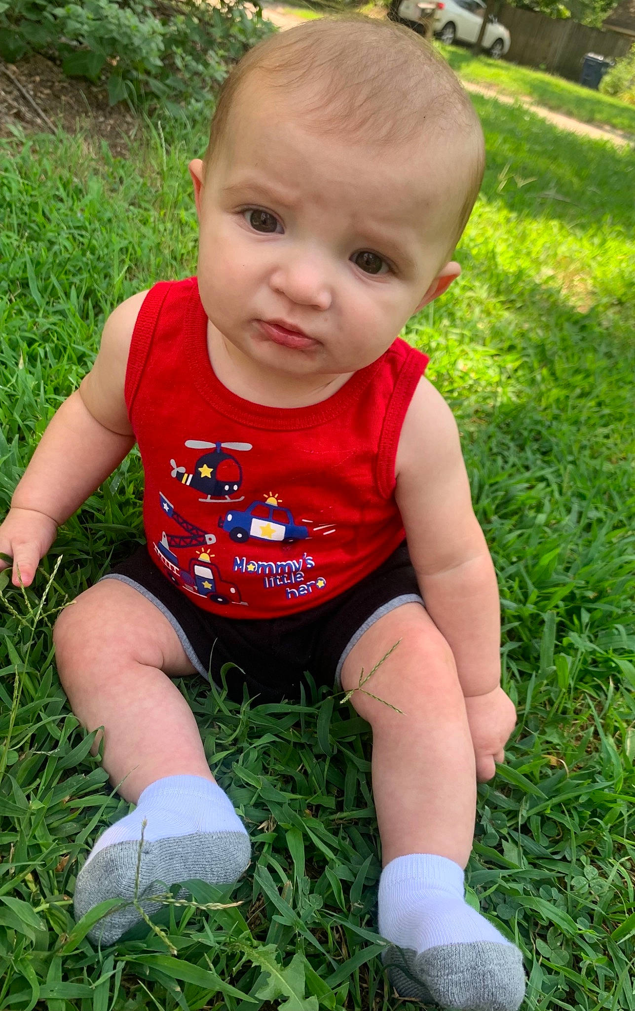Everett is registered to the contest to win money with this photo: baby, baby_toddler_clothing, cheek, face, finger, fun, grass, hair, hairstyle, happy, head, human_body, leg, meadow, people_in_nature, person, plant, shorts, skin, t_shirt