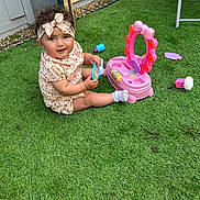 Gabriella is registered to the contest to win money with this photo: toddler, child, toy, pink_toy, headband, grass, outdoor, play, mirror, smiling, baby, socks, dress, garden, sunlight, cute, fun, happy, floor, plastic_toy