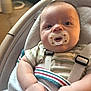 baby, pacifier, infant, child, face, arm, hand, clothing, striped_shirt, baby_seat, seatbelt, indoor, carrying_seat, cushion, person, portrait, soft_lighting, closeup, cute, newborn