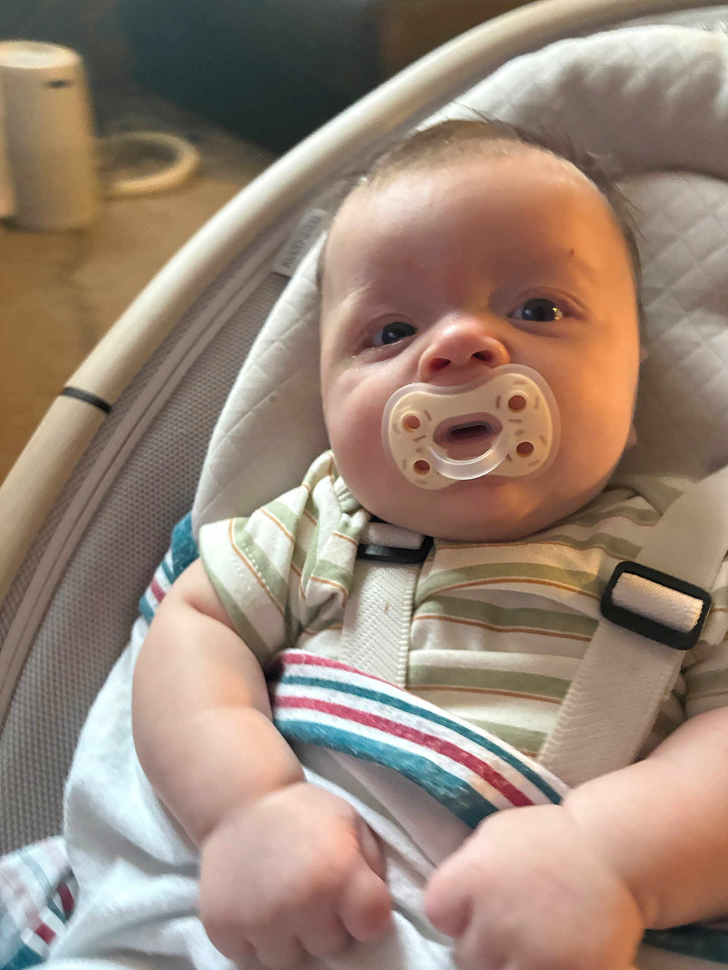 Asher joined the competition — help win amazing prizes! baby, pacifier, infant, child, face, arm, hand, clothing, striped_shirt, baby_seat, seatbelt, indoor, carrying_seat, cushion, person, portrait, soft_lighting, closeup, cute, newborn