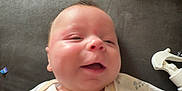 Asher joined the competition — help win amazing prizes! baby, infant, onesie, giraffe, embroidery, couch, baby_wipes, spray_bottle, smiling, happy, skin, hand, face, child, indoors, soft_furniture, blanket, closeup, cute, newborn