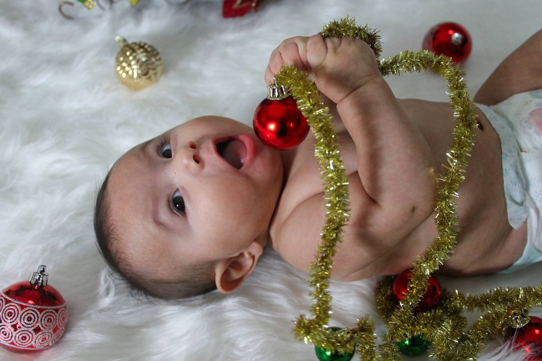 Sergio is registered to the contest to win money with this photo: arm, baby, body_jewelry, child, christmas_ornament, close_up, dress, facial_expression, grass, hand, happy, human_body, jewellery, leaf, lip, person, red, skin, sunglasses, surprise