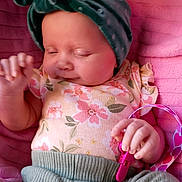 Elizabeth joined the competition — help win amazing prizes! baby, infant, sleeping, headband, floral_clothing, pink_blanket, toy, green_pants, hand, face, cute, peaceful, child, newborn, soft_texture, indoor, portrait, closeup, resting, adorable