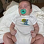 Evan is registered to the contest to win money with this photo: baby, infant, sleeping, pacifier, onesie, clothing, blanket, indoor, child, cute, peaceful, relaxing, person, newborn, soft_lighting, furniture, bedroom, comfort, nap, resting