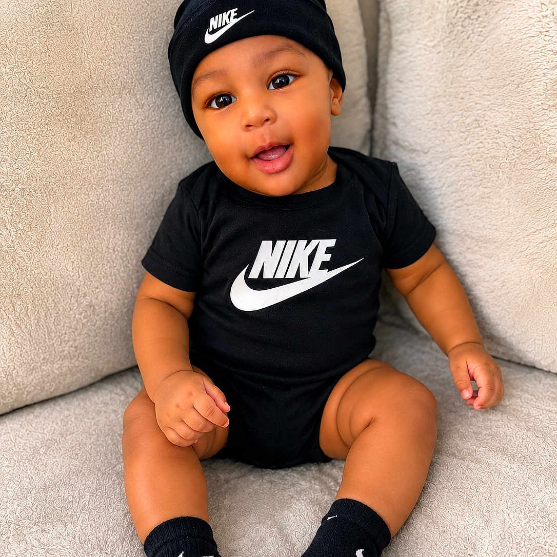 Camiri joined the competition — help win amazing prizes! baby, child, nike, black_clothing, black_hat, black_socks, smiling, sitting, indoor, couch, plush, comfortable, cute, happy, person, portrait, infant, fashion, logo, apparel