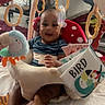 Camiri is registered to the contest to win money with this photo: baby, infant, play_seat, toy, plush_toy, hanging_rings, smiling, child, indoor, hands, striped_shirt, floor_mat, colorful, comfort, parental_care, cuddly_toy, feet, head_support, happy, cute