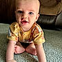 baby, child, crawling, carpet, blue_eyes, yellow_shirt, animal_print, indoor, couch, furniture, cute, infant, person, skin, hand, face, expression, hair, toe, room