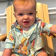 Weston is registered to the contest to win money with this photo: baby, child, infant, shirt, colorful_clothing, patterned_shirt, wooden_chair, smiling, happy, sitting, indoors, cute, portrait, skin, face, blue_eyes, short_hair, one_person, casual, arm