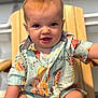 baby, child, infant, shirt, colorful_clothing, patterned_shirt, wooden_chair, smiling, happy, sitting, indoors, cute, portrait, skin, face, blue_eyes, short_hair, one_person, casual, arm