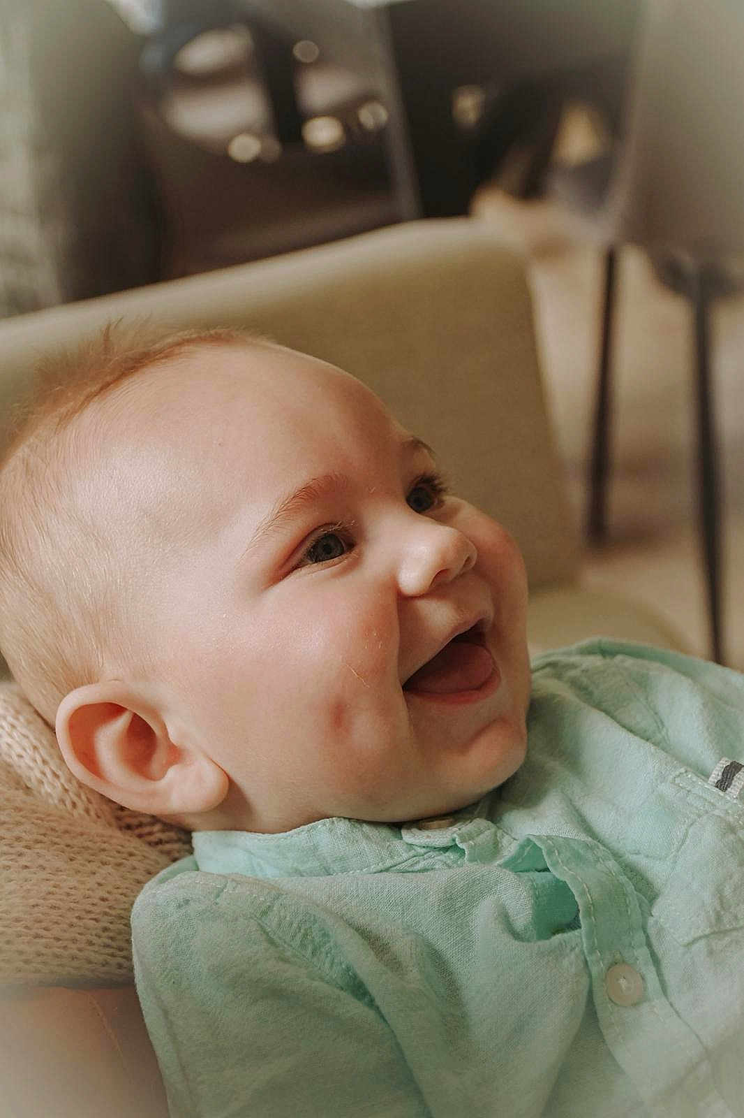 Athanase participe au concours pour gagner de l'argent avec cette photo : baby, smile, dimples, face, child, happy, clothing, mint_green, shirt, knitted_cushion, cozy, portrait, indoor, infant, cheerful, closeup, head, skin, expression, young_child