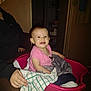 baby, child, person, laundry_basket, blanket, pink, smile, indoor, adult, hand, clothing, face, seated, home, furniture, doorway, towel, flash, cozy, happy