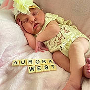 Aurora West is registered to the contest to win money with this photo: adorable, baby, blanket, child, closeup, cozy, cute, flower_headband, infant, lace_clothing, letters, name, newborn, peaceful, pink, portrait, resting, sleeping, soft_texture, tiles