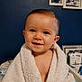 baby, child, towel, smile, face, blue_wall, photograph, frame, indoor, person, skin, happy, portrait, young, cute, infant, wrapped, soft, background, home