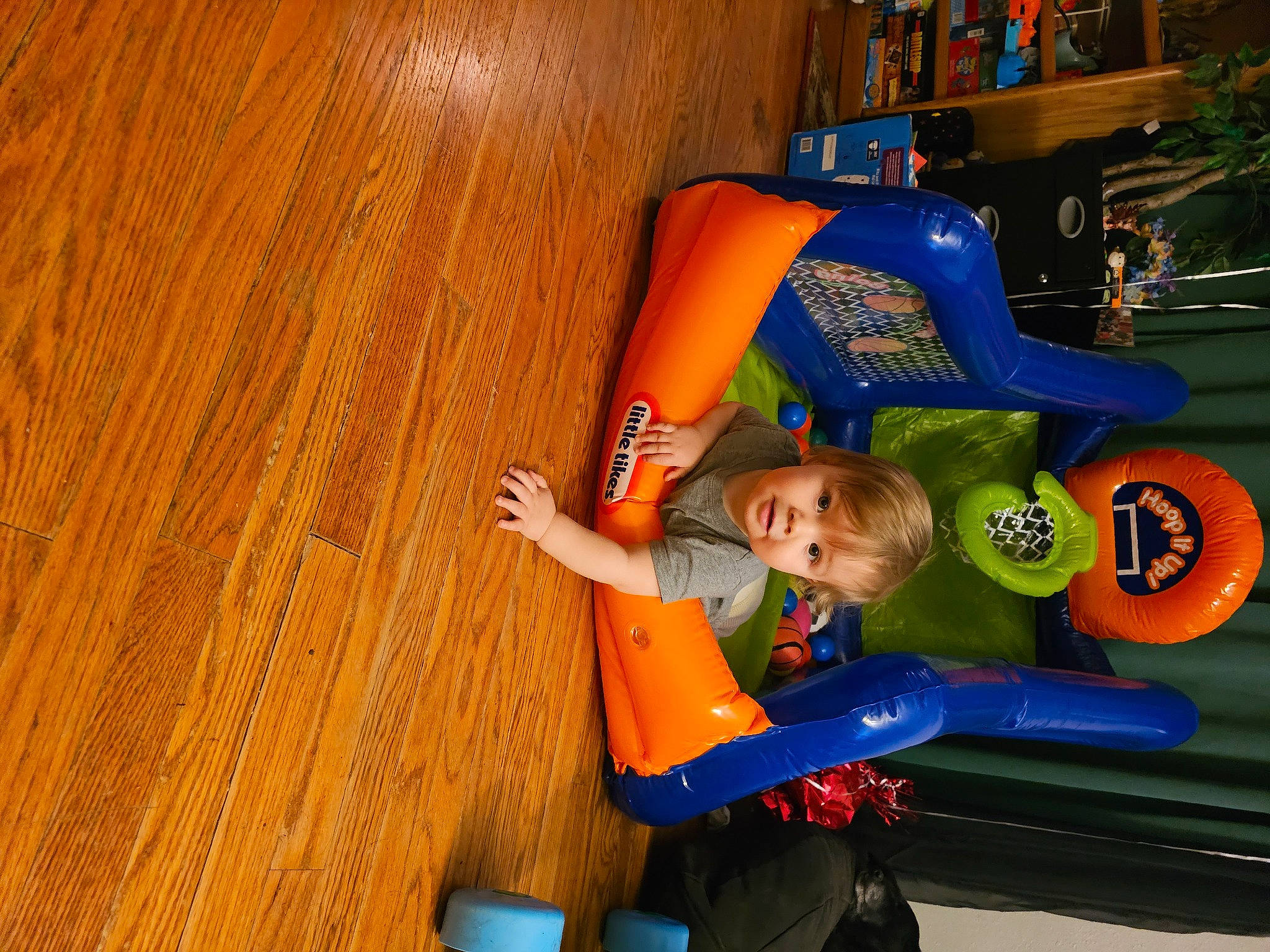Gabriel is registered to the contest to win money with this photo: child, chute, electric_blue, flooring, fun, hardwood, laminate_flooring, leisure, orange, person, play, recreation, shelf, sitting, sportswear, t_shirt, toddler, varnish, wood, wood_flooring