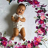 Mia joined the competition — help win amazing prizes! baby, smiling, infant, blanket, floral_pattern, flower, hummingbird, white_background, cute, lying_down, happy, child, portrait, soft_texture, colorful, nature_motif, clothing, one_person, indoors, playful