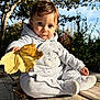 baby, child, autumn, leaf, outdoor, trees, wooden_deck, sky, sunlight, nature, cute, cozy_clothing, grey_outfit, sitting, portrait, fall, seasonal, face, expression, young_child