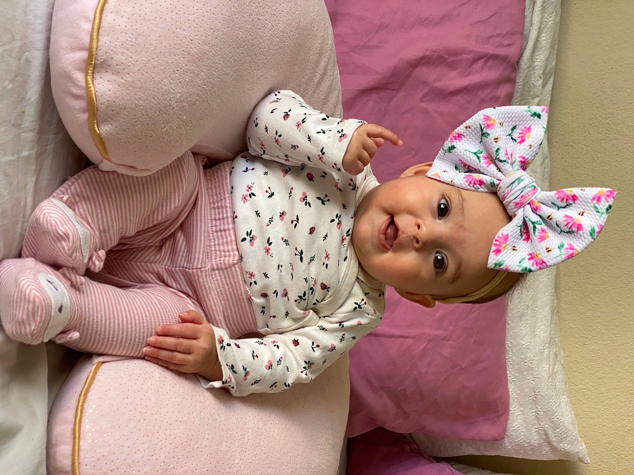 Elise is registered to the contest to win money with this photo: arm, baby, baby_products, baby_sleeping, baby_toddler_clothing, cheek, child, comfort, facial_expression, headwear, human, linens, pattern, person, pink, room, sitting, skin, sleeve, sun_hat