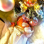 Cecelia joined the competition — help win amazing prizes! baby, newborn, pacifier, headband, ornament, christmas_tree, holiday, sleeping, striped_pajamas, pink_bow, snowy_branches, festive, decoration, soft_texture, white_fur, infant, cute, peaceful, indoors, closeup