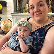 Camilla joined the competition — help win amazing prizes! woman, baby, indoor, portrait, denim_overalls, headband, bow, globe, marbles, smile, holding, casual_clothing, necklace, furniture, face, person, curious, skin, baby_clothes, home