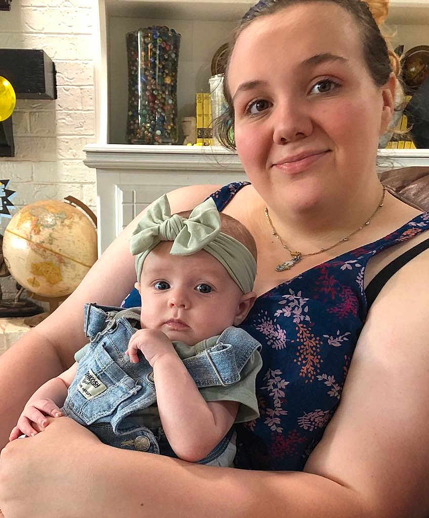 Camilla joined the competition — help win amazing prizes! woman, baby, indoor, portrait, denim_overalls, headband, bow, globe, marbles, smile, holding, casual_clothing, necklace, furniture, face, person, curious, skin, baby_clothes, home