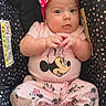 baby, infant, child, portrait, car_seat, polka_dots, pink, bow, headband, minnie_mouse, disney, clothing, sneakers, socks, sitting, indoors, wide_eyed, hands, smiling, colorful