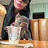 woman, dog, puppy, bulldog, coffee, starbucks, cup, table, glasses, earrings, leash, indoor, furniture, chair, beverage, casual, portrait, brown, black_hair, close_up