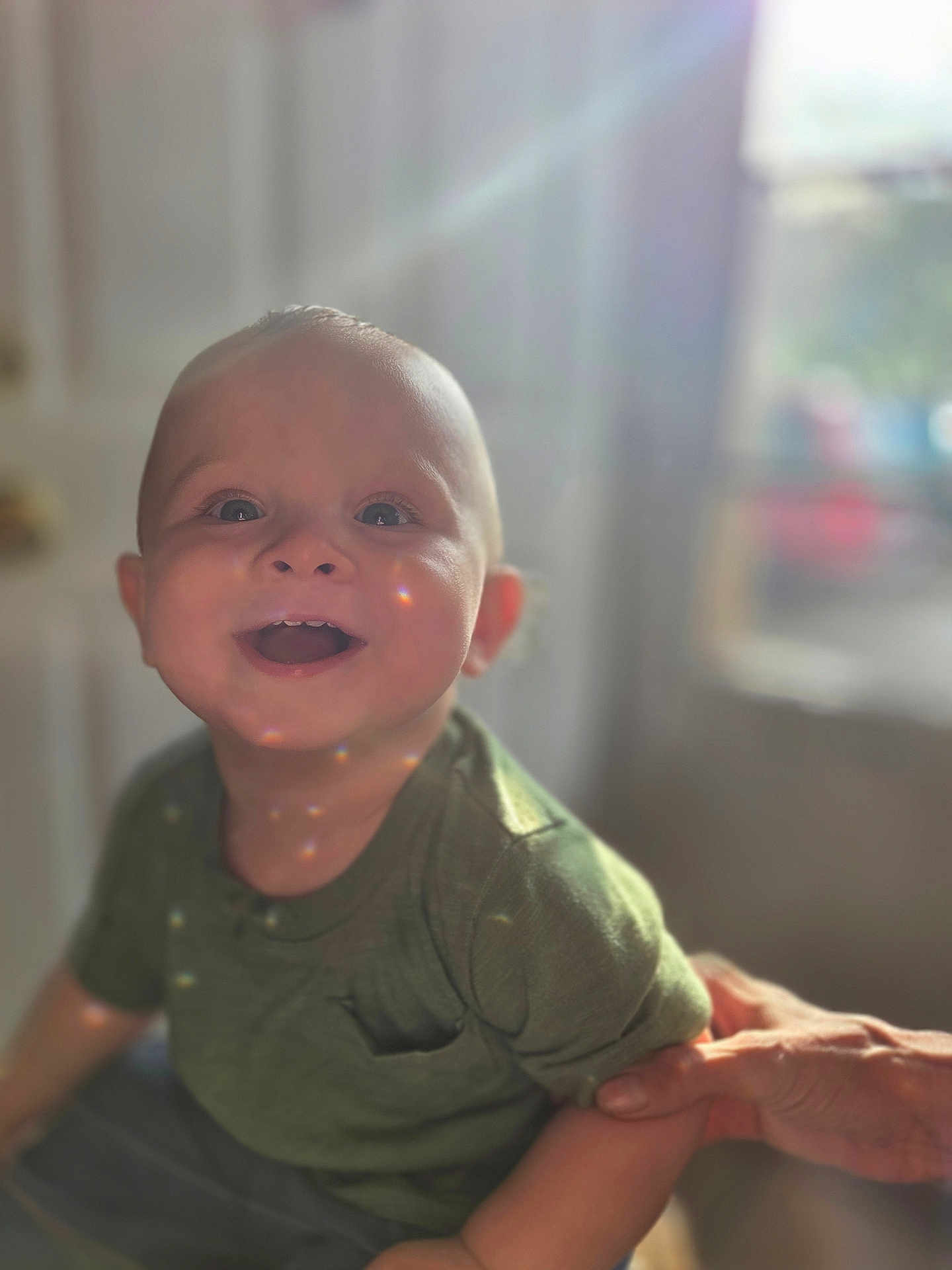 Liam joined the competition — help win amazing prizes! baby, child, smiling, happy, portrait, indoor, natural_light, lens_flare, green_shirt, person, infant, cute, hand, supporting_hand, face, eyes, skin, short_hair, toddler, warm