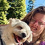 Jaxson is registered to the contest to win money with this photo: person, dog, outdoor, smiling, glasses, tattoo, happy, pet, nature, trees, sunlight, portrait, closeup, canine, cuddling, purple_clothing, leash, face, summer, blue_sky