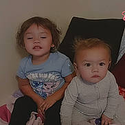Katalina joined the competition — help win amazing prizes! children, toddler, baby, siblings, portrait, sitting, bed, bedroom, indoor, smiling, serious_expression, brown_hair, light_hair, cartoon_shirt, gray_clothing, black_pants, blanket, pillows, sparkles, home
