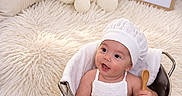 Herick is registered to the contest to win money with this photo: baby, bedroom, celebration, chef_hat, child, cute, fluffy_rug, indoor, infant, metal_bucket, milestone, pillows, plush_toys, portrait, sitting, smiling, teddy_bears, three_months, white_clothing, wooden_spoon