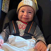 Carson joined the competition — help win amazing prizes! baby, infant, child, smiling, car_seat, car_interior, knitted_hat, winter_clothing, blanket, safety_harness, seated, portrait, face, hands, happy, indoors, vehicle, close_up, fabric, photography
