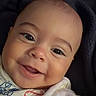 baby, child, infant, smiling, happy, portrait, face, eyes, indoor, blanket, clothing, onesie, cartoon, colorful, close_up, head, sitting, cozy, photography, adorable