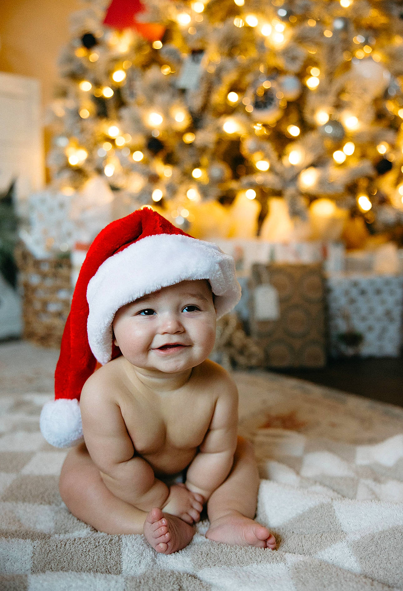 Winston is registered to the contest to win money with this photo: baby, baby_toddler_clothing, child, christmas, christmas_decoration, christmas_eve, christmas_ornament, christmas_tree, event, foot, happy, headwear, holiday, holiday_ornament, human_body, joy, ornament, person, plant, santa_claus