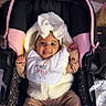baby, infant, car_seat, bow, white_bow, smiling, cozy_clothing, bib, footwear, pink, black, child, happy, indoors, cute, person, seat, wearing_white, blanket, toddler