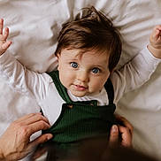 Asher joined the competition — help win amazing prizes! baby, child, infant, hands, bed, white_bedspread, green_clothing, portrait, cute, looking_up, person, human, skin, face, eyes, hair, smiling, lying_down, tenderness, parent