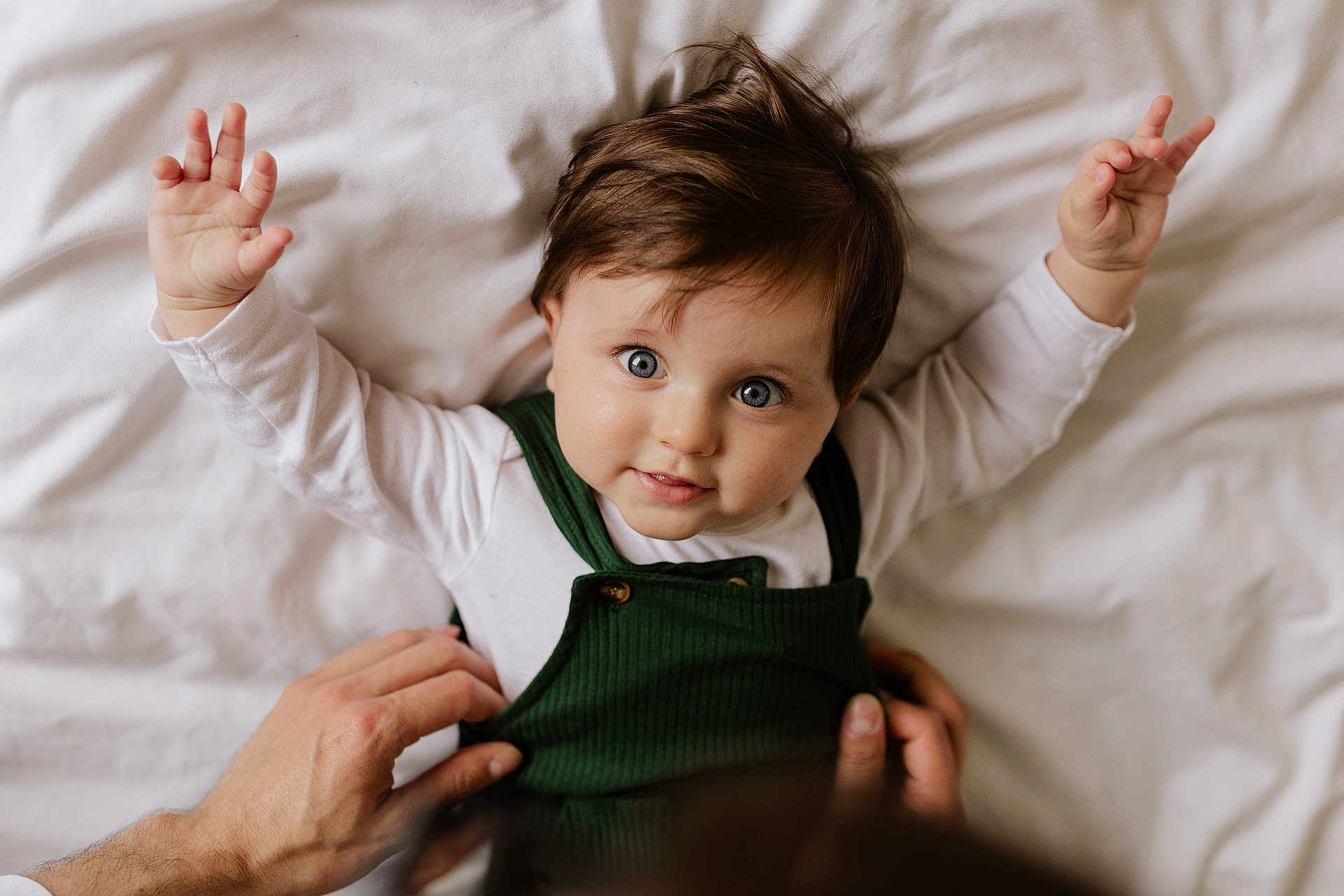 Asher joined the competition — help win amazing prizes! baby, child, infant, hands, bed, white_bedspread, green_clothing, portrait, cute, looking_up, person, human, skin, face, eyes, hair, smiling, lying_down, tenderness, parent