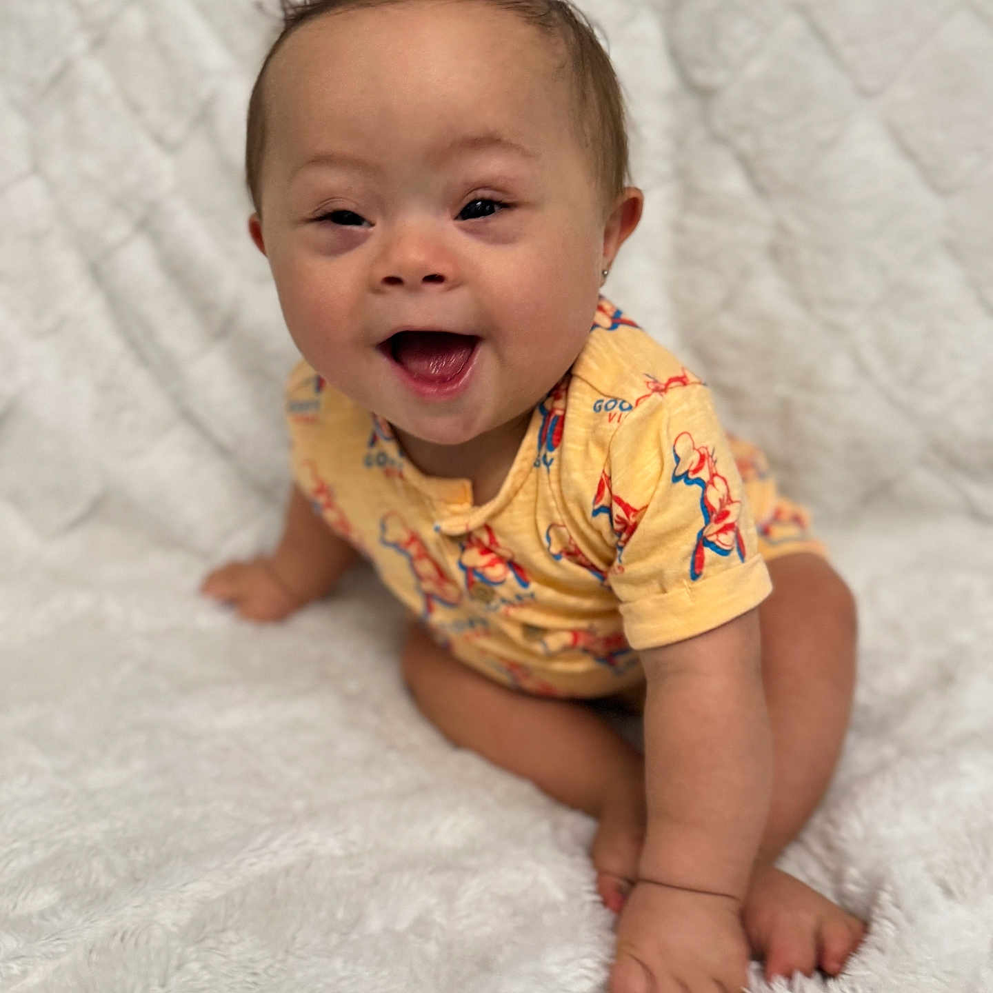 Avery-Ray is registered to the contest to win money with this photo: baby, blanket, child, crawling, cute, earrings, eyes, face, hair, happy, indoor, infant, mouth, one_person, portrait, skin, smiling, soft_texture, white_background, yellow_clothing