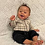Avery-Ray joined the competition — help win amazing prizes! baby, child, smiling, plaid_shirt, black_pants, barefoot, sitting, happy, indoors, blanket, soft_texture, cute, portrait, toddler, furniture, cozy, joyful, hand_wave, young_child, face