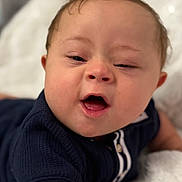 Avery-Ray joined the competition — help win amazing prizes! baby, child, infant, face, smiling, mouth_open, hair, skin, blue_shirt, blanket, lying_down, cute, expression, indoors, soft_texture, portrait, toddler, happy, closeup, person